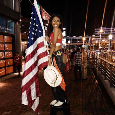 Woman standing and holding United States of America flag.